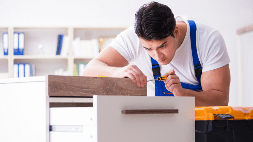 Man assembling furniture with a screwdriver.